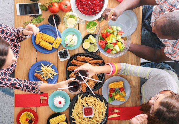 Vista superior do grupo de pessoas jantando juntos enquanto está sentado na mesa de madeira comida na mesa p