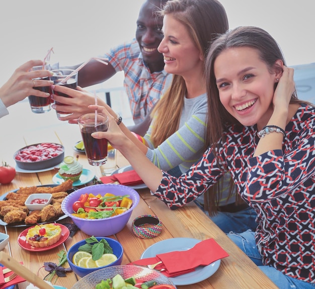 Vista superior do grupo de pessoas jantando juntos enquanto está sentado na mesa de madeira comida na mesa p