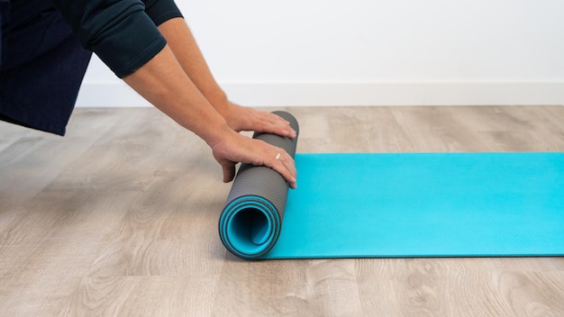 Vista superior do homem caucasiano com colchonete se preparando para treinamento esportivo de ioga em casa interior Medite e exercícios de treino de fitness em casa