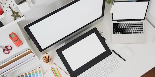 Vista superior do local de trabalho de designer gráfico com tablet de tela em branco e computador desktop