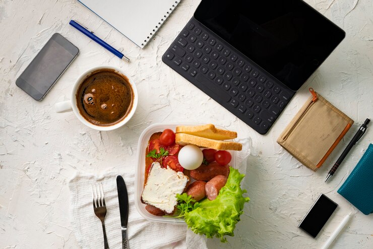 Foto vista superior do local de trabalho do escritório com computador ou caneta para laptop e telefone, almoço nutritivo durante os trabalhos