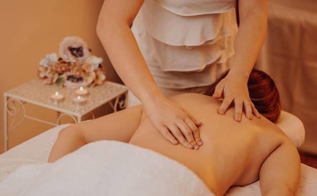 Foto vista superior do massagista feliz massageando a jovem de volta a uma mesa de massagem conceito de tratamento de spa de massagem