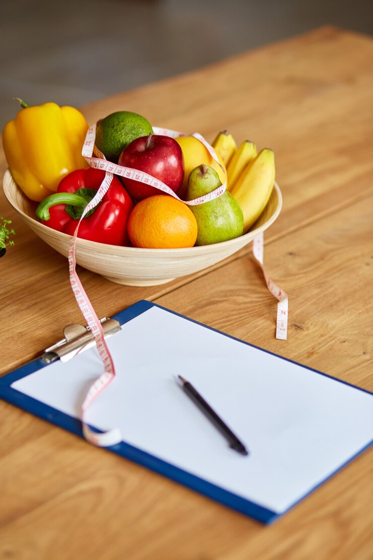Foto vista superior do nutricionista, local de trabalho do nutricionista com fita métrica e tigela com frutas e vegetais saudáveis