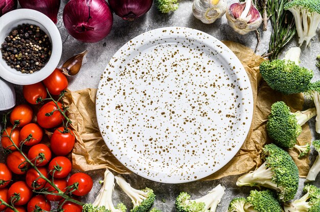 Vista superior do prato entre legumes não cozidos. conceito de cozinha vegetariana em casa