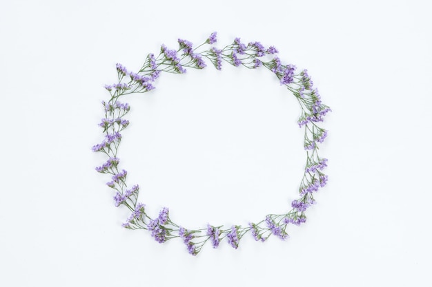 Vista superior do quadro redondo da flor com flores violetas e copie o espaço isolado no fundo branco, configuração lisa. Conceito de cartão