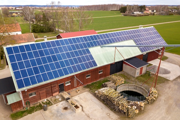 Foto vista superior do sistema solar azul dos painéis voltaicos da foto no telhado de madeira da construção, do celeiro ou da casa. conceito de produção de energia verde ecológica renovável.