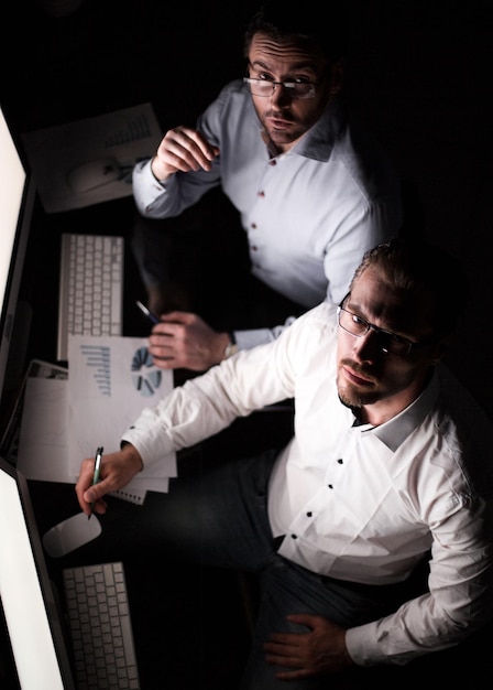 Foto vista superior de dos empleados sentados en el escritorio de la oficina