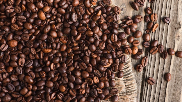 Vista superior dos grãos de café espalhados na serapilheira na superfície de madeira