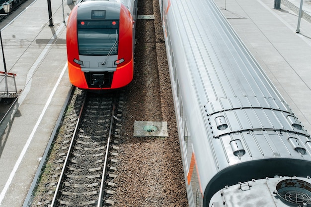 Vista superior de dos modernos trenes de pasajeros de alta velocidad que corren sobre rieles en la estación de tren al aire libre