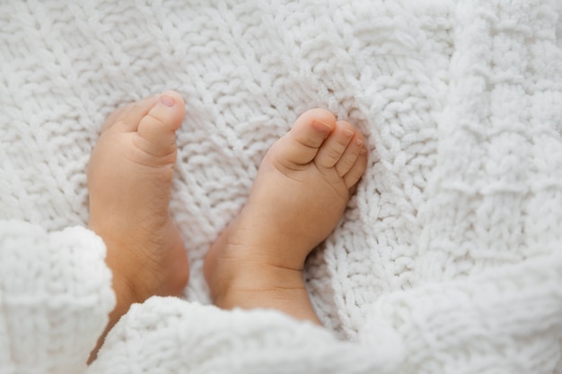 Foto vista superior dos pés minúsculos do bebê na manta branca