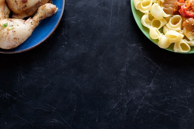 Vista superior de dos platos con pasta y pollo frito copia espacio