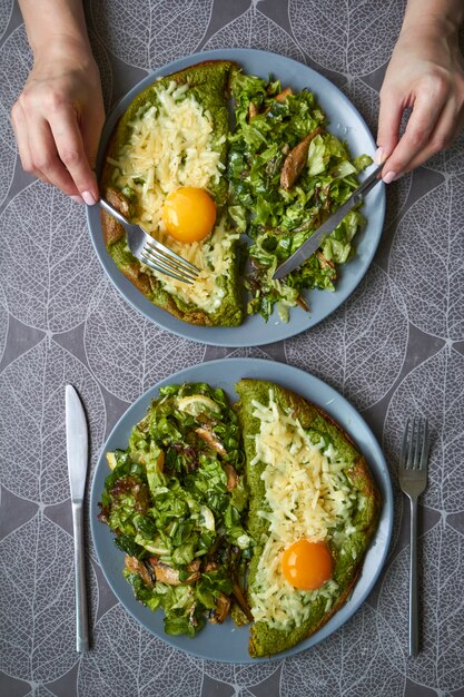 Vista superior de dos platos con tortilla y ensalada sobre la mesa