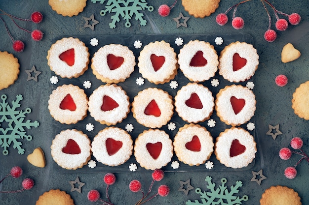 Vista superior dos tradicionais biscoitos de Natal Linzer com geléia vermelha no escuro