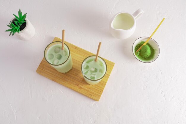 Vista superior de dos vasos de té verde matcha latte con cubitos de hielo una bebida refrescante aminoácidos antioxidantes fondo blanco