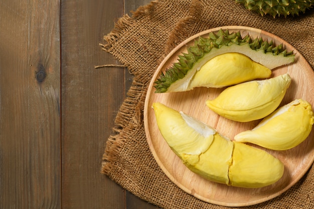 Foto vista superior de durian fresco (un mes) en plato de madera