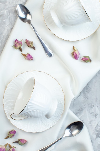 Vista superior elegante taza con plato cuchara y flores en superficie blanca color horizontal vidrio comida cocina mesa de cocina