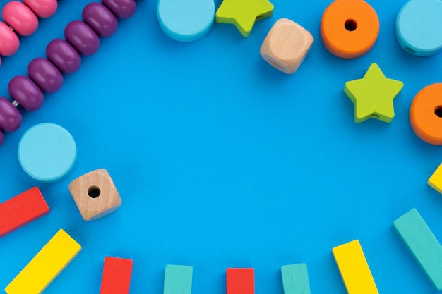 Vista superior em jogos educativos infantis, quadro com brinquedos de crianças multicoloridas em papel azul