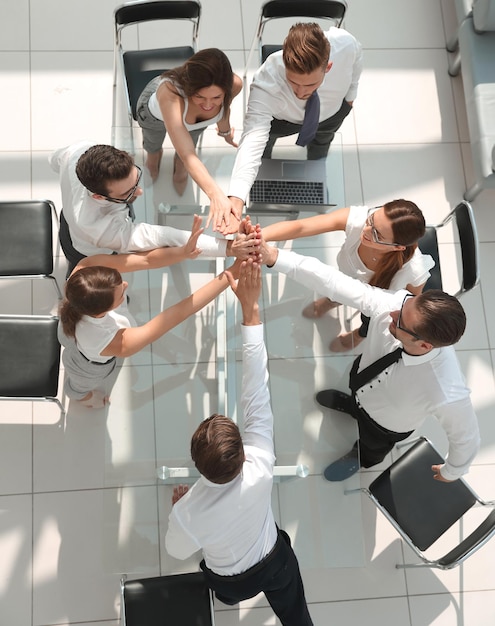 Foto vista superior de los empleados de la empresa mostrando su unidad el concepto de trabajo en equipo