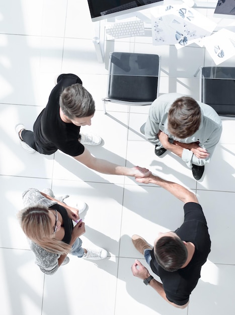 Vista superior de empresarios dándose la mano después de sellar un trato Vista de ángulo alto del apretón de manos casual de mujeres empresarias después de concluir un acuerdo comercial