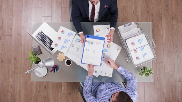 Foto vista superior de empresarios que comparten documentos de la empresa analizando el beneficio financiero