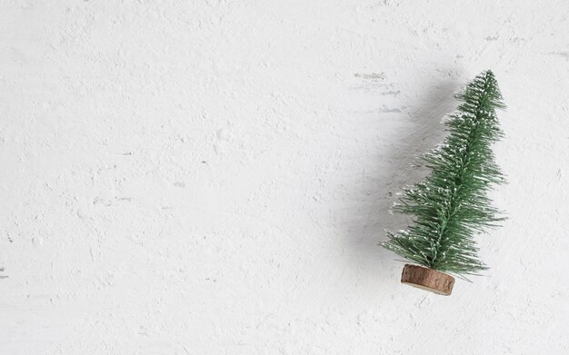 Vista superior de la endecha plana de la mini madera del árbol de navidad en la tabla de madera blanca rústica.