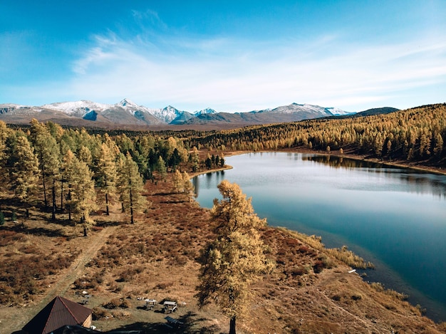 Vista superior de un enorme lago de aguas profundas con aguas turquesas cristalinas, ubicado junto a un denso bosque