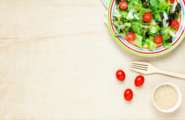 Foto vista superior de ensalada de cocina con salsa en la mesa de madera con copia espacio.