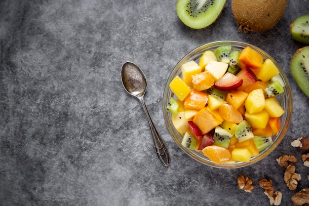 Vista superior de ensalada de frutas saludables: mango, cítricos, kiwi, ciruela y caqui.