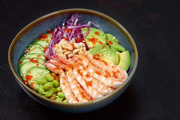 Vista superior de ensalada poke con gambas rojas y vegetales verdes en los tazones sobre fondo gris Copiar espacio