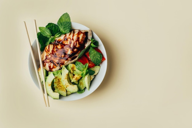 Vista superior de una ensalada con verduras de carne y frutas sazonadas con salsa sobre un fondo beige con espacio libre para texto