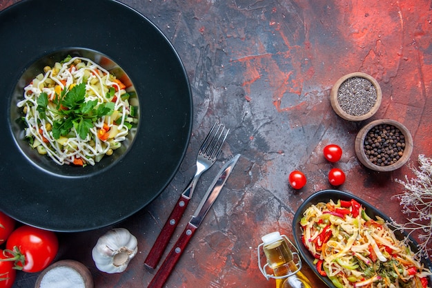 Vista superior ensalada de verduras decoradas dentro de la placa con tomates rojos superficie oscura color de comida cocina horizontal dieta de alimentos almuerzo de salud