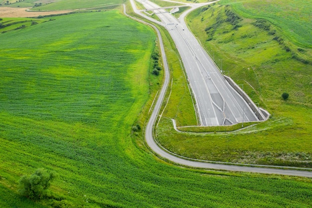 Vista superior de la entrada del túnel de la carretera cubierta de hierba verde