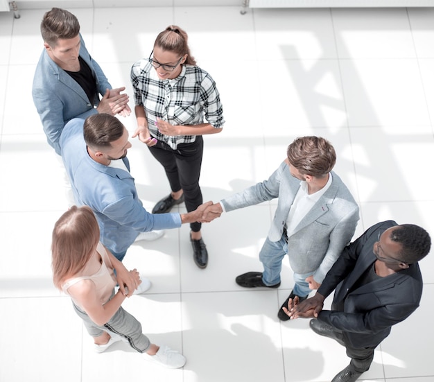 Vista superior del equipo de negocios de pie sobre el concepto de fondo blanco de trabajo en equipo exitoso