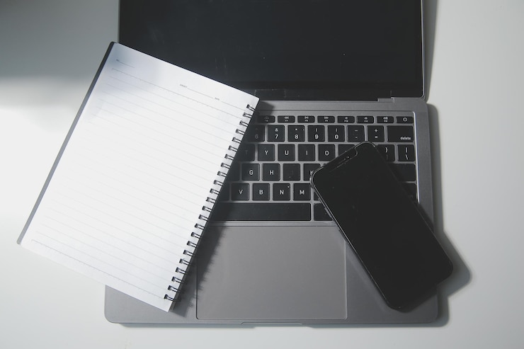 Foto vista superior del escritorio de la computadora con teclado, papelería de teléfono inteligente y trazado de recorte de taza de café