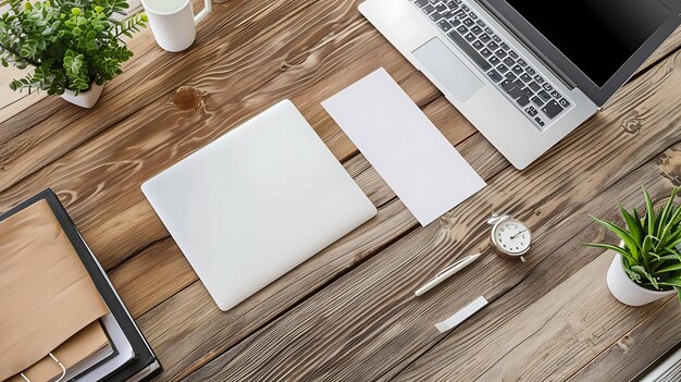 Vista superior de un escritorio de madera con una computadora portátil una planta un reloj un bolígrafo dos hojas en blanco de papel y una taza de café