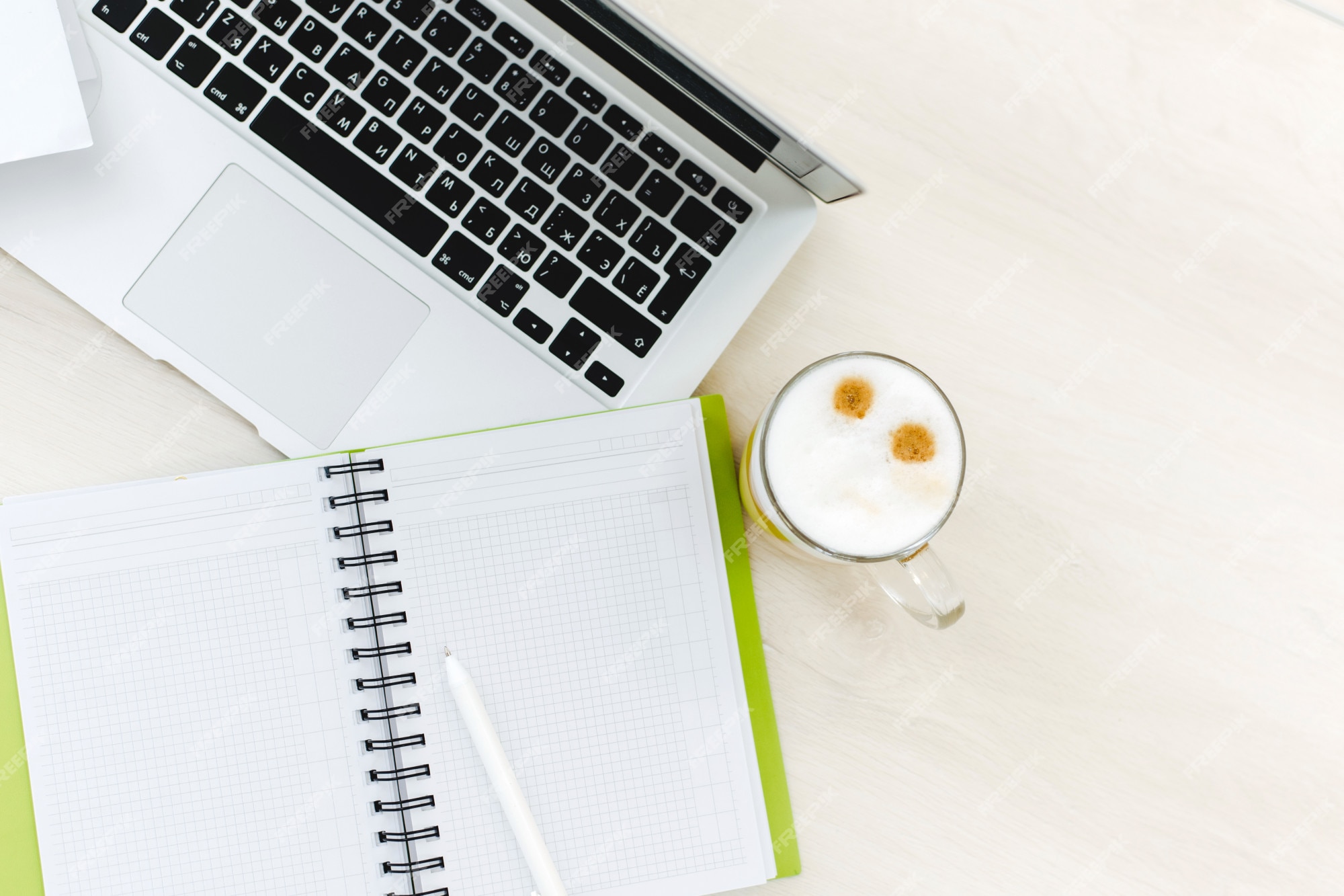 Vista superior del escritorio de oficina con ordenador portátil, portátiles y taza de café fondo de color mesa de oficina con cuaderno en blanco y | Foto Premium