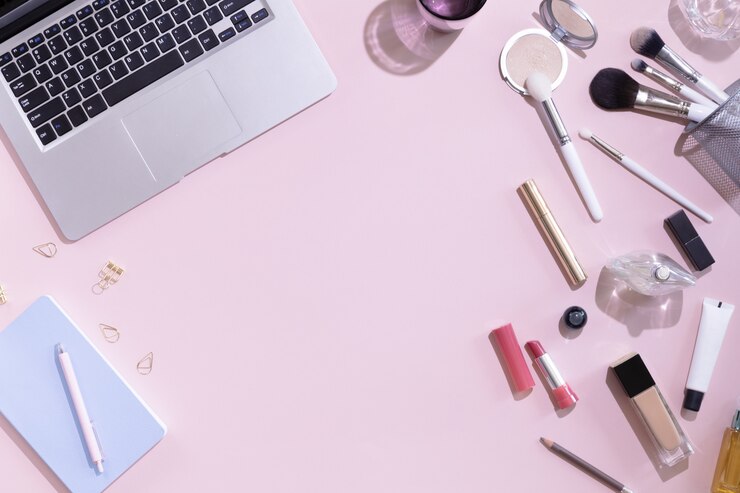 Foto vista superior del escritorio de trabajo de blogger de belleza de mujer con computadora o computadora portátil, cuaderno, cosmética decorativa, deja sombras y luz dura, sobre en mesa de color rosa y blanco pastel. fondo plano laico.