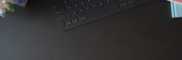 Vista superior del espacio de trabajo de concepto oscuro con teclado inalámbrico y espacio de copia