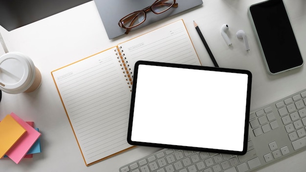 Vista superior del espacio de trabajo creativo con tableta digital, nota adhesiva y teléfono inteligente