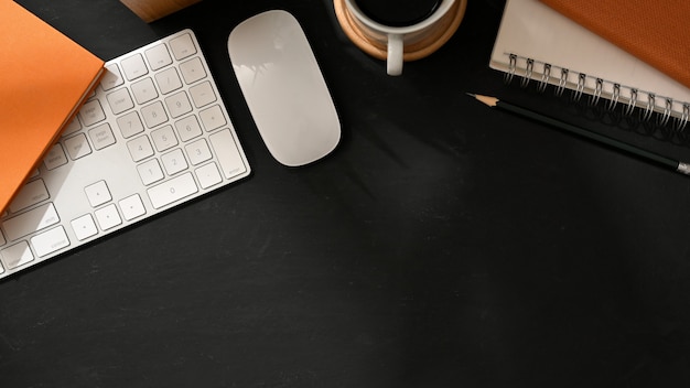 Vista superior del espacio de trabajo plano creativo con teclado de computadora, mouse, papelería y espacio para copiar