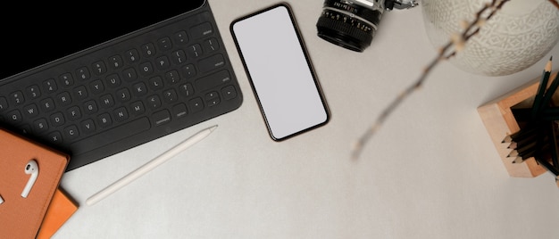 Foto vista superior del espacio de trabajo simple con teléfono inteligente con trazado de recorte, suministros de oficina y espacio para copiar en la mesa de mármol