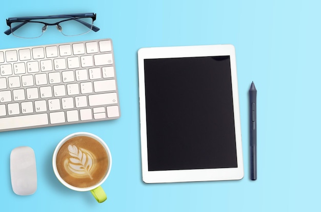 Vista superior Espaço de trabalho Minmal com teclado de óculos e espaço de cópia de xícara de café em fundo azul