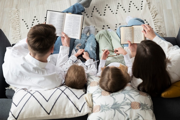 Foto vista superior familia cristiana leyendo la biblia juntos