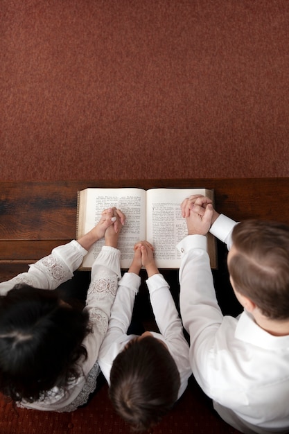 Foto vista superior familia cristiana leyendo la biblia