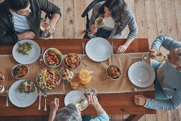 Vista superior de la familia multigeneracional comunicándose mientras cenan juntos