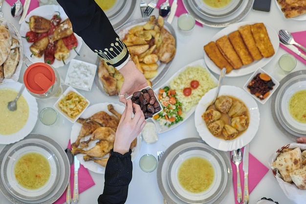 Vista superior de la familia musulmana que tiene Iftar durante el mes sagrado del Ramadán. Feliz familia musulmana árabe rompiendo el ayuno juntos.