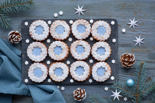 Vista superior de flores Linzer cookies con glaseado azul en invierno oscuro