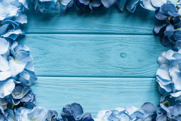 Vista superior de fondo azul de madera con marco floral