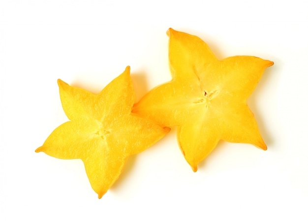 Vista superior de la forma de estrella amarilla vibrante de dos frutas maduras en rodajas sobre fondo blanco