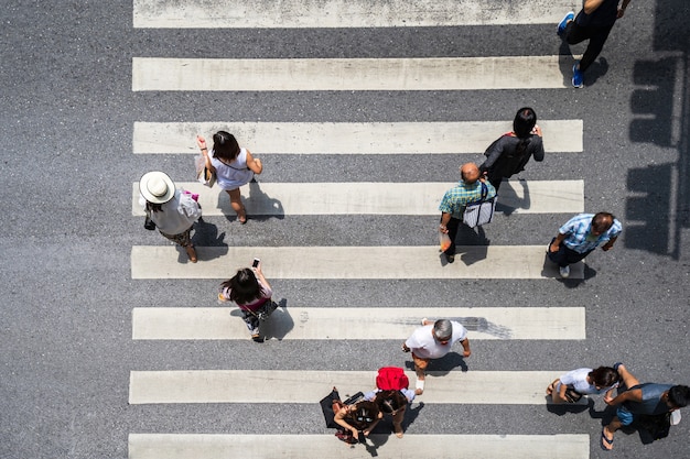 La vista superior de la foto aérea de la gente camina en la calle en la ciudad sobre el camino del tráfico de paso de peatones